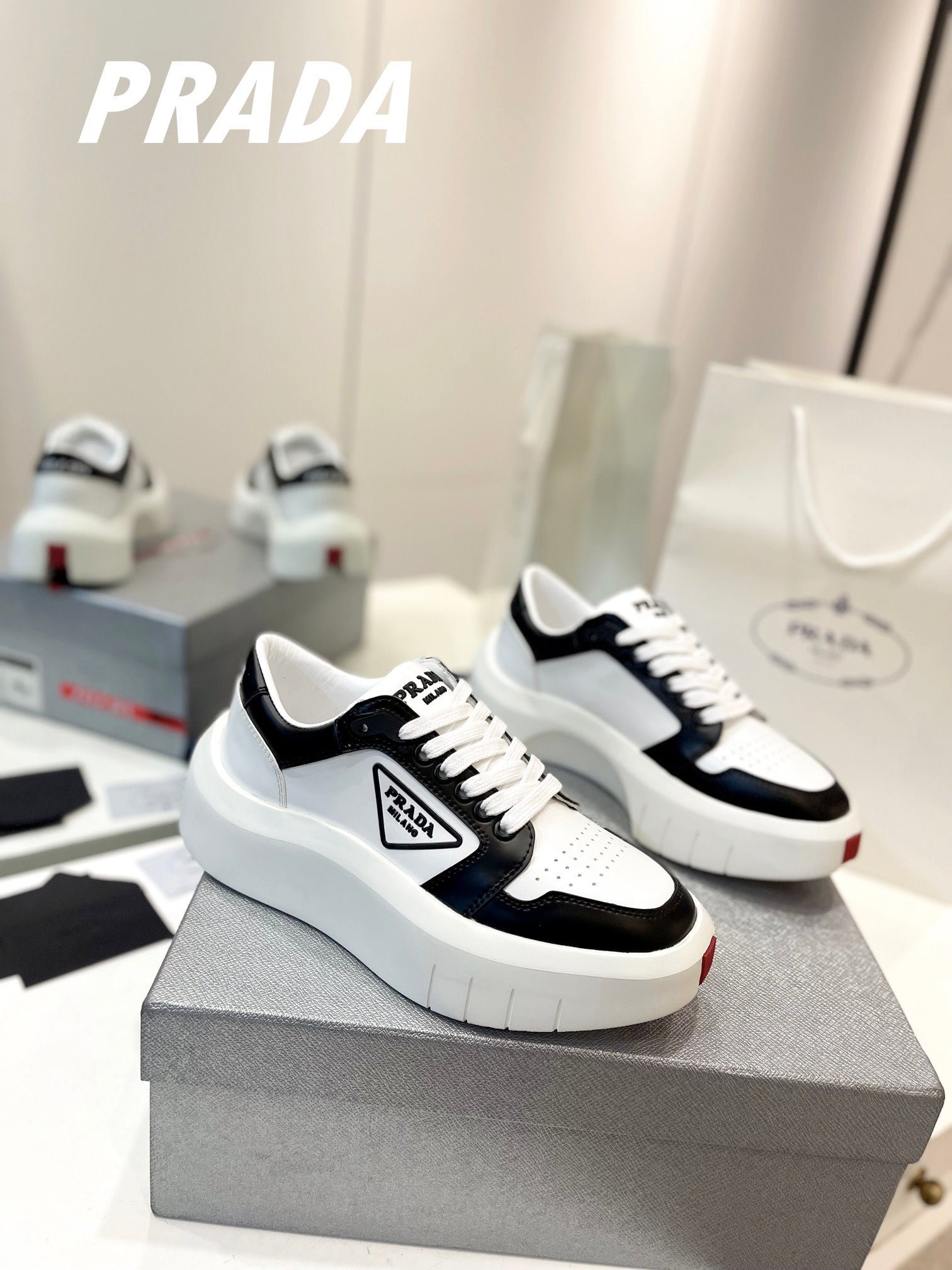PRADA DOWNTOWN THICK-SOLE SNEAKERS BLACK AND WHITE CALFSKIN