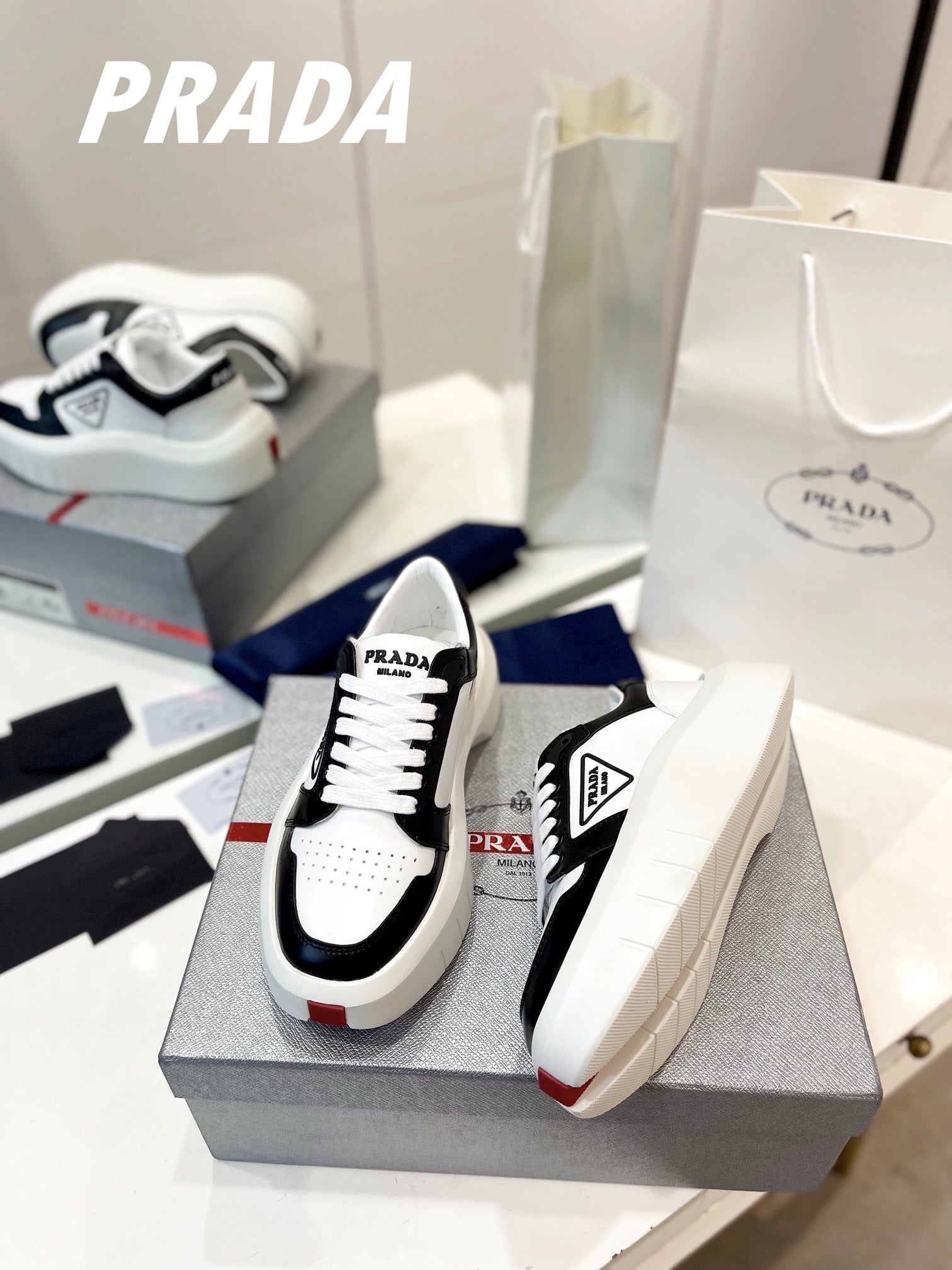 PRADA DOWNTOWN THICK-SOLE SNEAKERS BLACK AND WHITE CALFSKIN