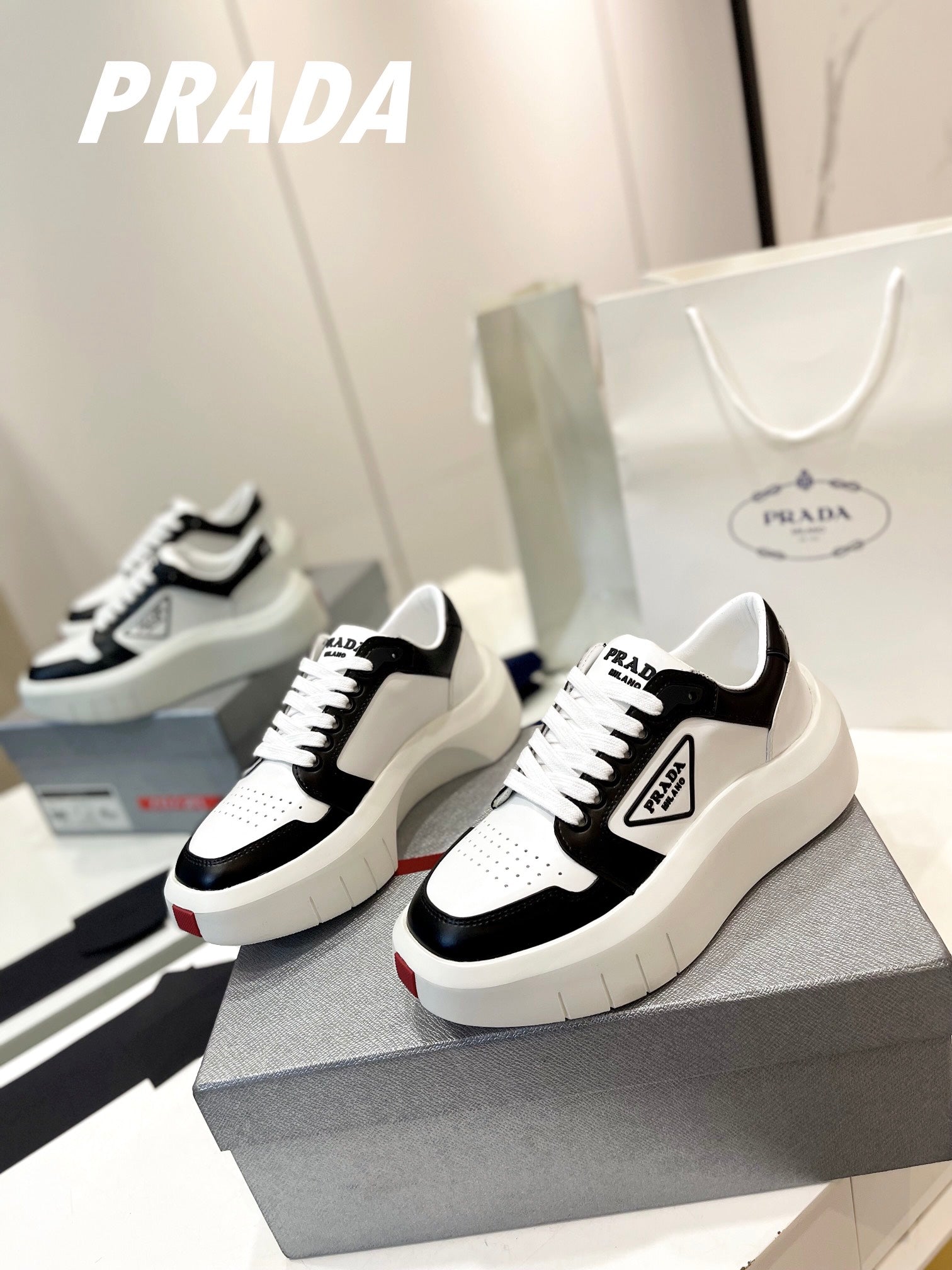 PRADA DOWNTOWN THICK-SOLE SNEAKERS BLACK AND WHITE CALFSKIN