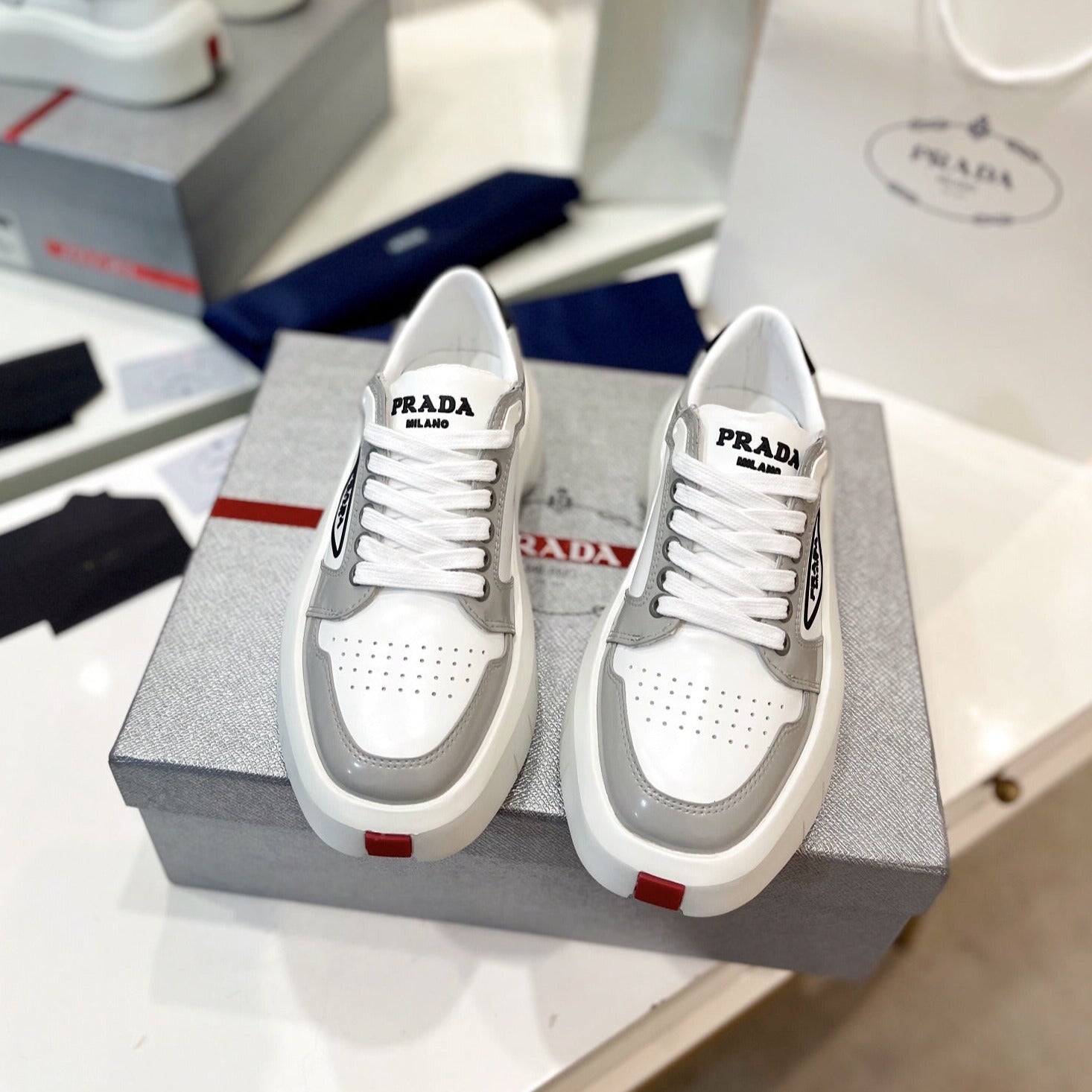 PRADA DOWNTOWN THICK-SOLE SNEAKERS WHITE AND GRAY CALFSKIN