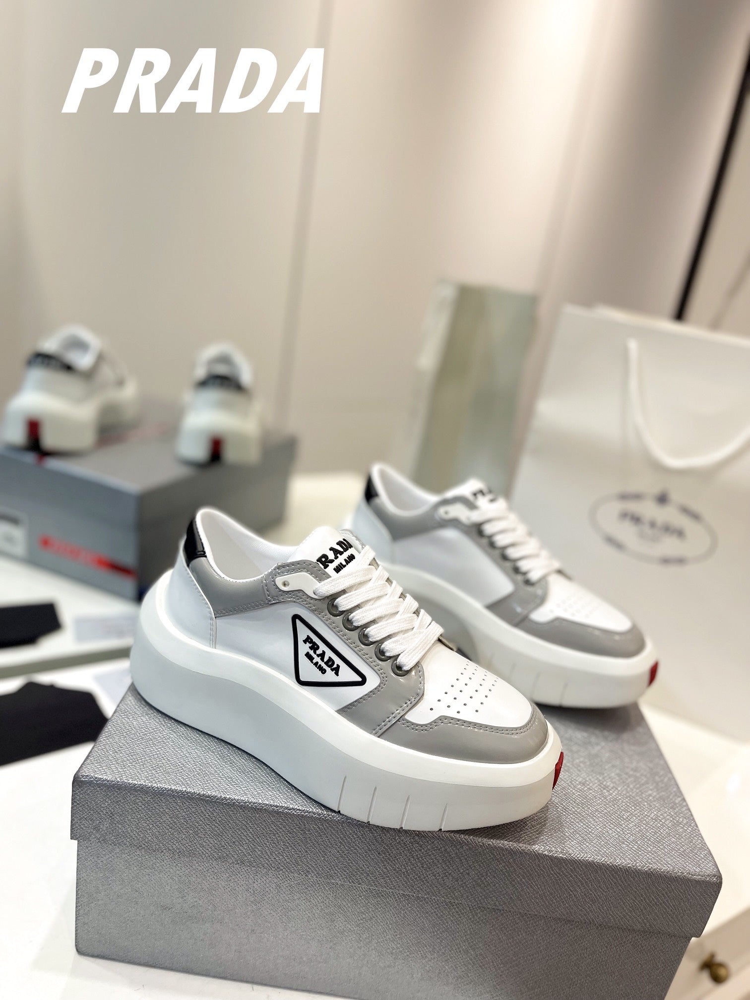 PRADA DOWNTOWN THICK-SOLE SNEAKERS WHITE AND GRAY CALFSKIN