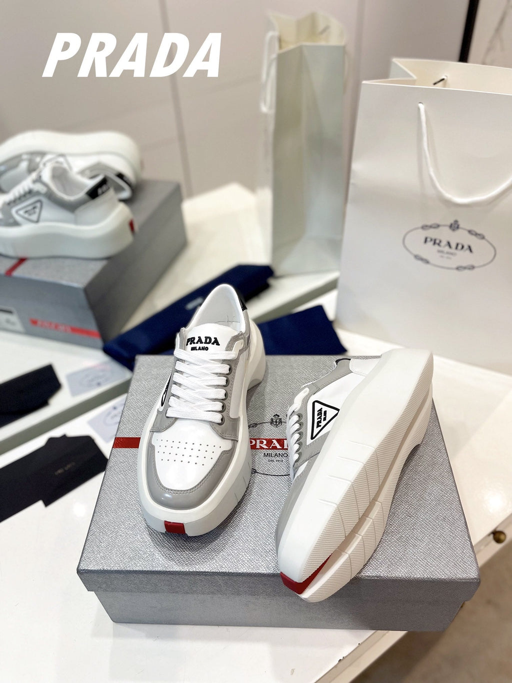PRADA DOWNTOWN THICK-SOLE SNEAKERS WHITE AND GRAY CALFSKIN