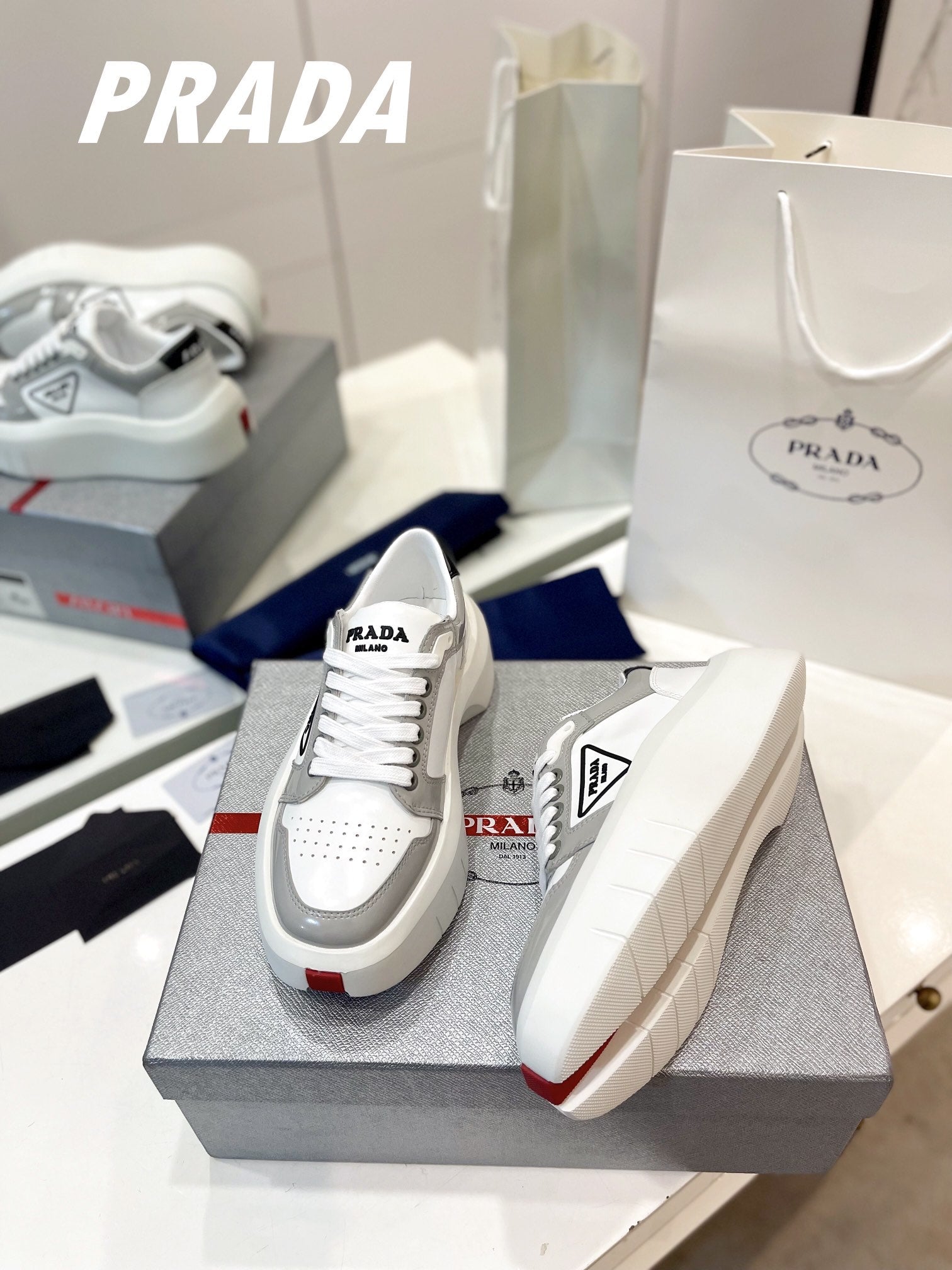 PRADA DOWNTOWN THICK-SOLE SNEAKERS WHITE AND GRAY CALFSKIN