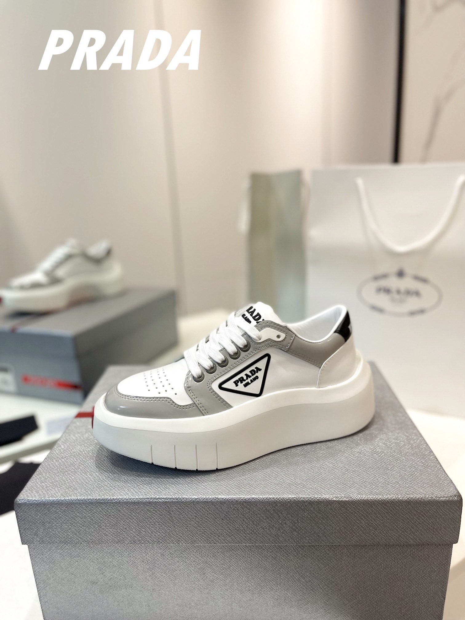 PRADA DOWNTOWN THICK-SOLE SNEAKERS WHITE AND GRAY CALFSKIN
